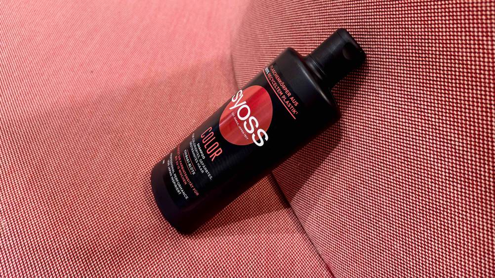 Color-Shampoo getestet: Eine Flasche von der Seite auf einem roten Polster.
