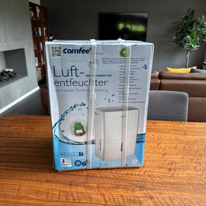 Der Karton des Comfee MDDF-20DEN7-WF steht auf einem Tisch