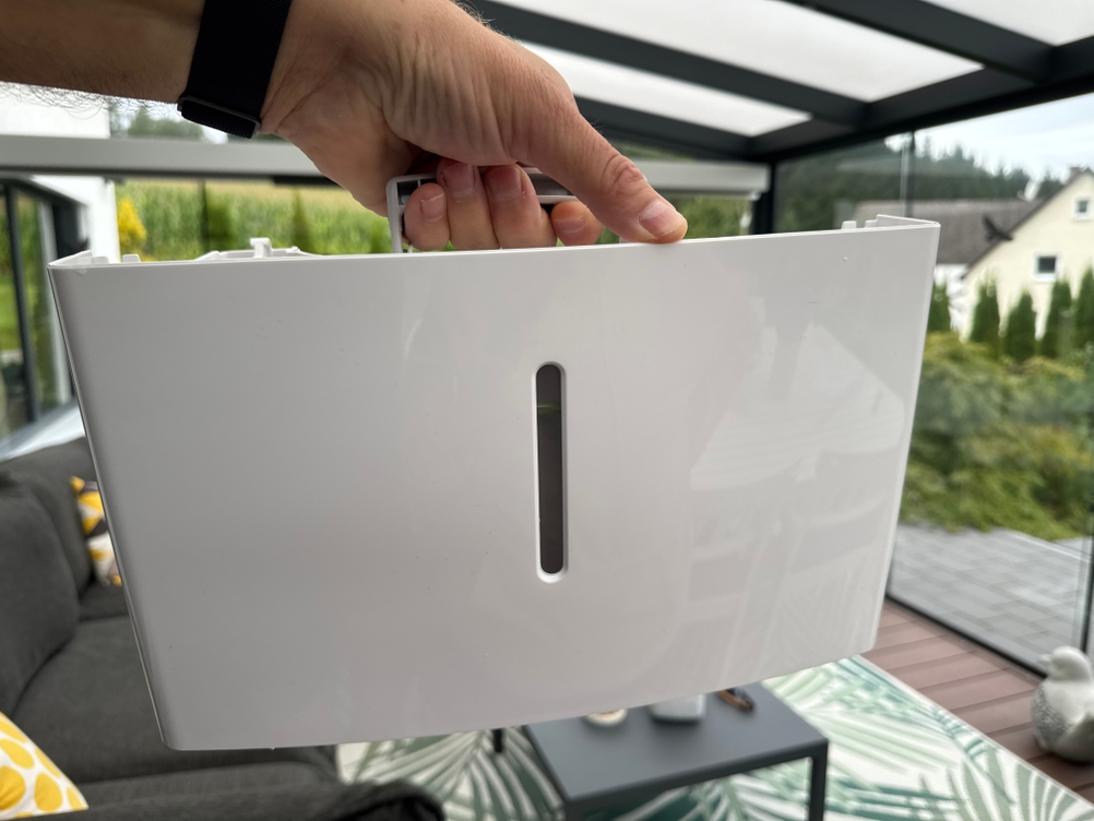 Eine Hand hält den mit Wasser gefüllten Behälter des Comfee MDDF-20DEN7-WF fest