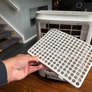 Eine Hand hält einen Filter des Comfee MDDF-20DEN7-WF fest