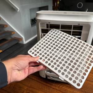 Eine Hand hält einen Filter des Comfee MDDF-20DEN7-WF fest