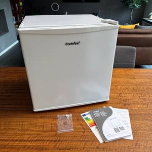 Der Lieferumfang des Comfee-RCD50WH2(E)-Mini-Kühlschranks steht auf einem Tisch.
