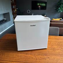 Der Comfee-RCD50WH2(E)-Mini-Kühlschrank steht auf einem Holztisch.