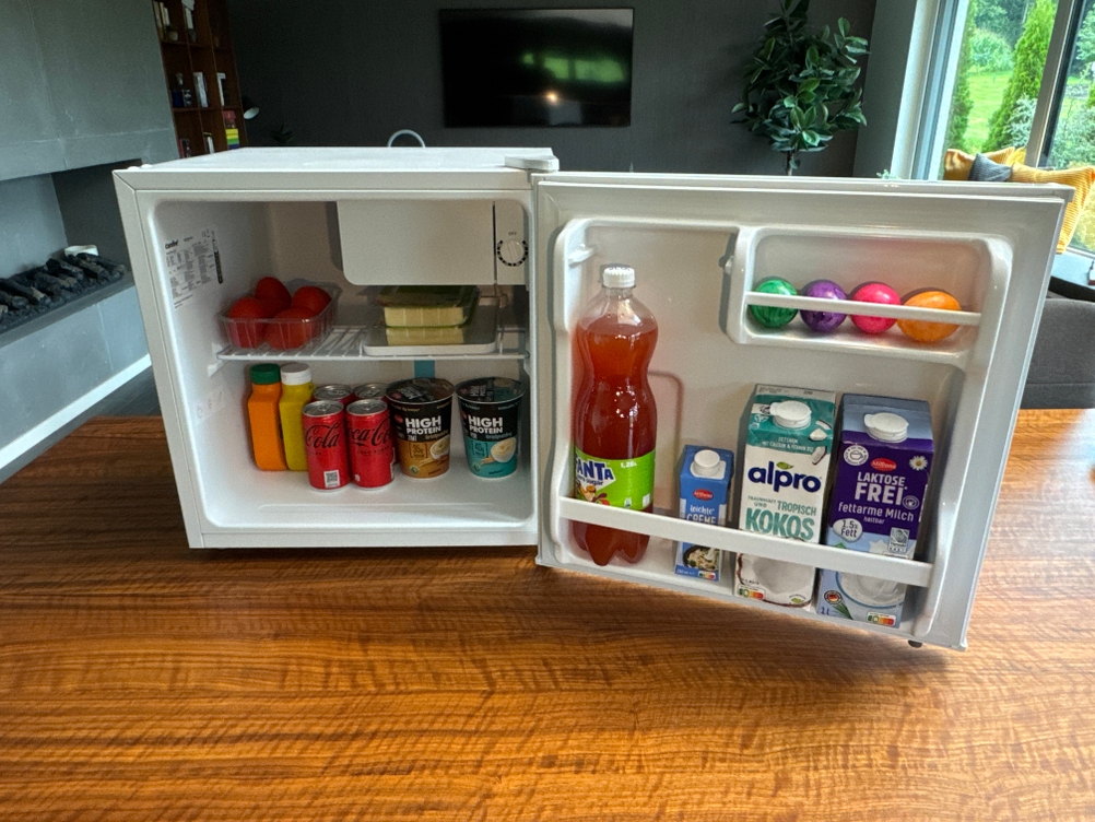 Der Comfee-RCD50WH2(E)-Mini-Kühlschrank ist gefüllt mit Lebensmitteln.
