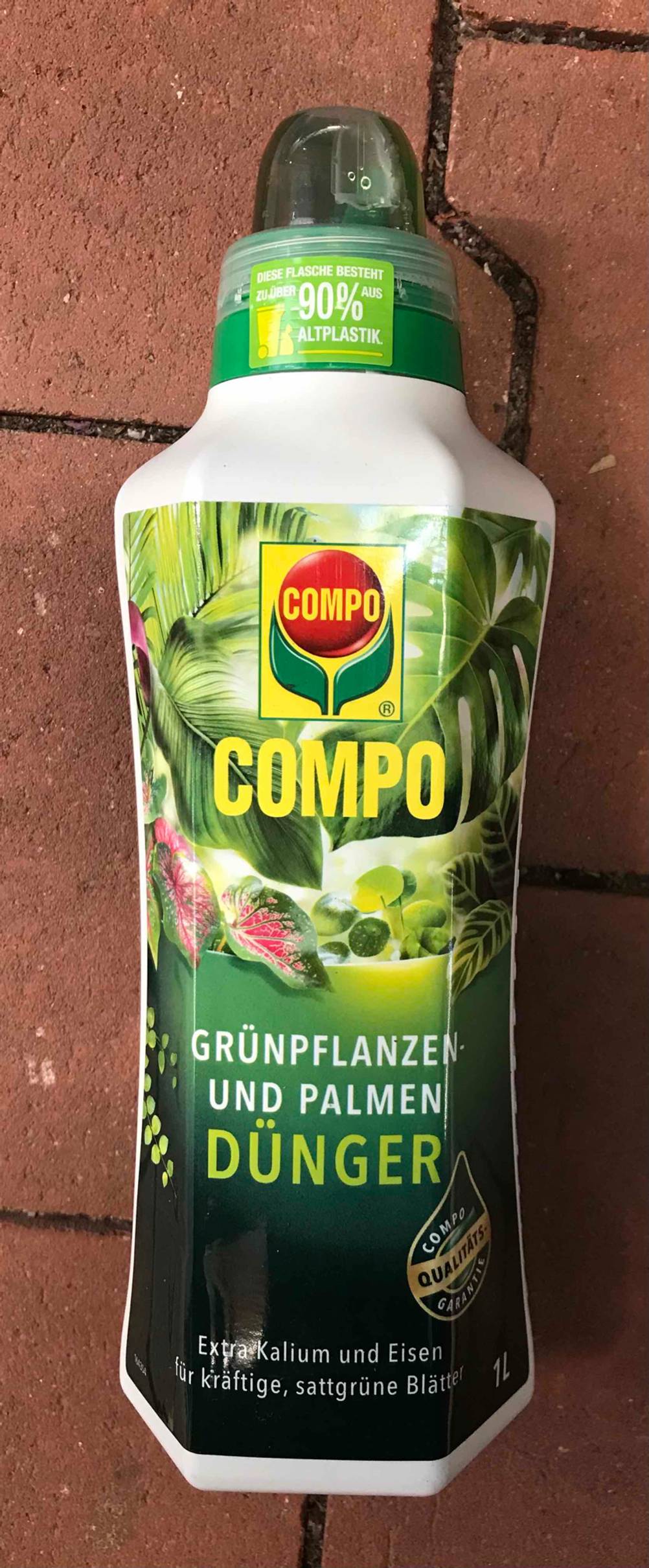 Im Test: Eine Flasche Palmendünger auf einer Steinfläche liegend.