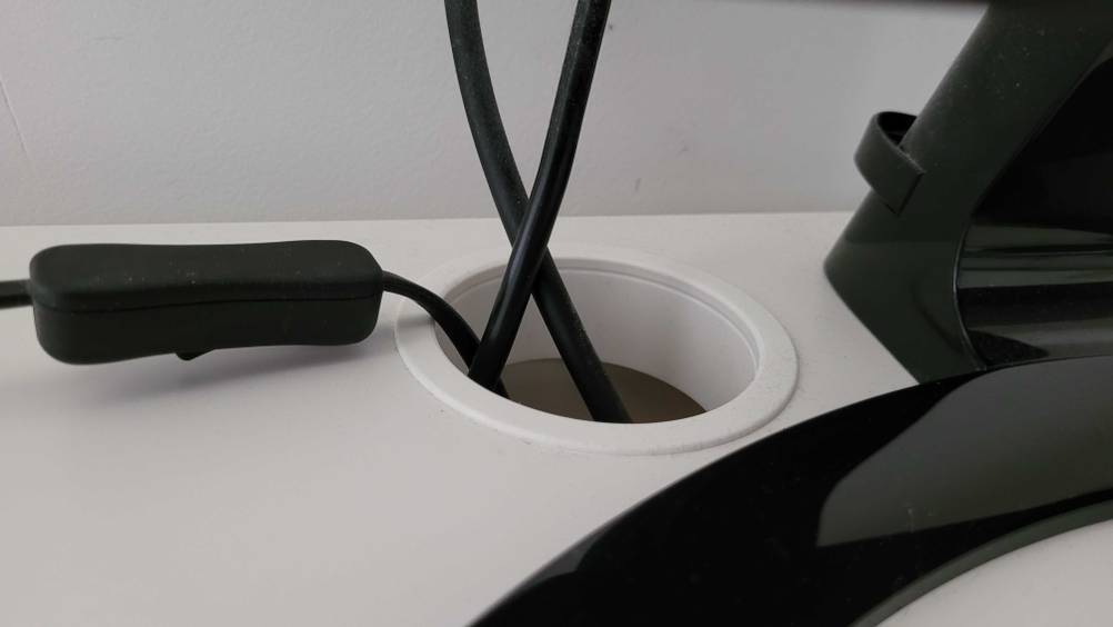 Getestet: Nahaufnahme der Kabeldurchführung an einem Computertisch.