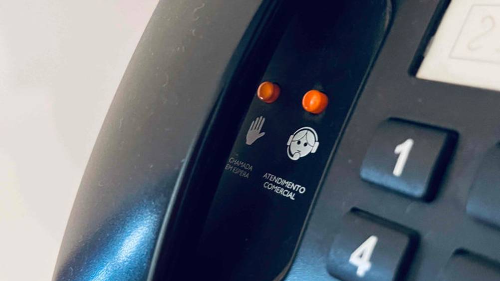 Schwarzes Seniorentelefon im Test: ein spanisches Modell mit orangen Notruftasten unter dem Hörer.