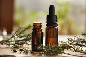 Copaiba-Öl-Test: Zwei Flaschen mit ätherischem Öl neben Thymian. 