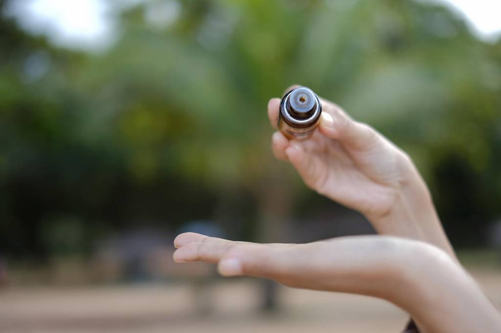 copaiba-öl-test: Eine Person tropf Öl auf die Handinnenfläche. 