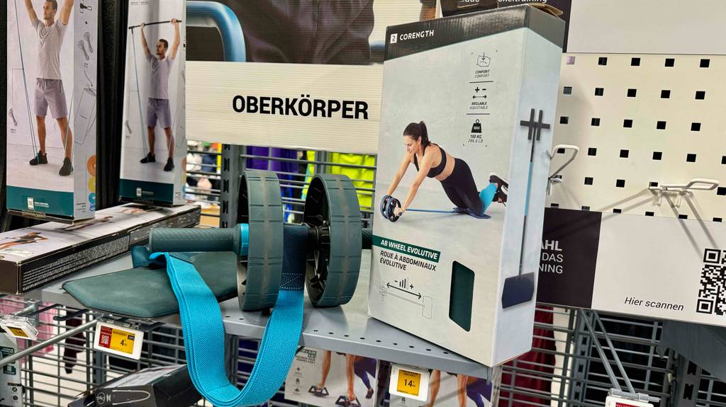 Ein Bauchtrainer liegt zum Testen neben der Originalvrpackung.