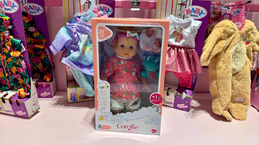Die getestete Corolle-Puppe in der transparenten Verpackung vor anderen Produkten auf einem Regal stehend.
