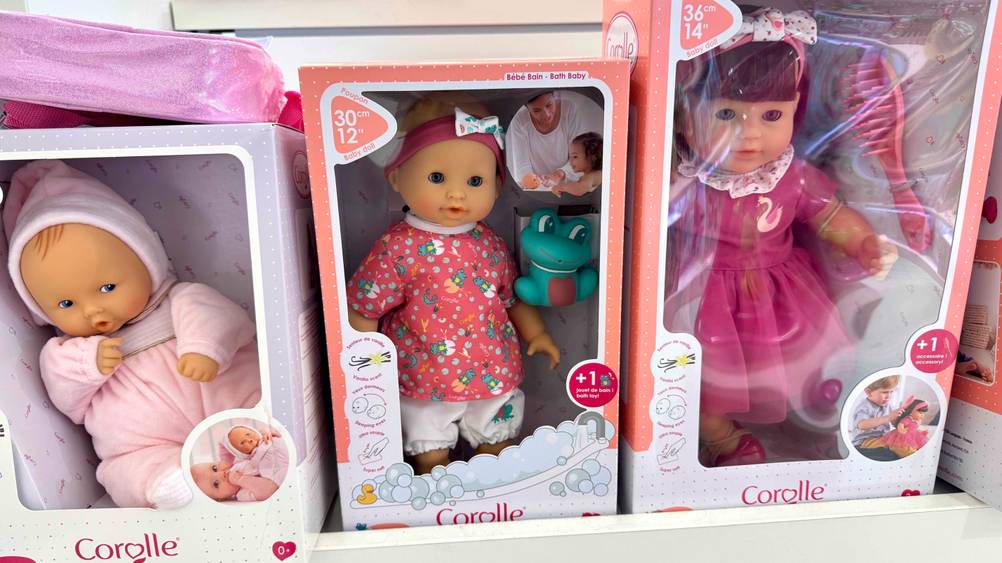 Getestet: Mehrere Corolle-Puppen stehen nebeneinander in einem Verkaufsregal.