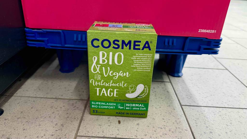 Getestete Bio-Slipeinlagen in der grünen 33-Stück-Packung befinden sich auf einem Fliesenboden.