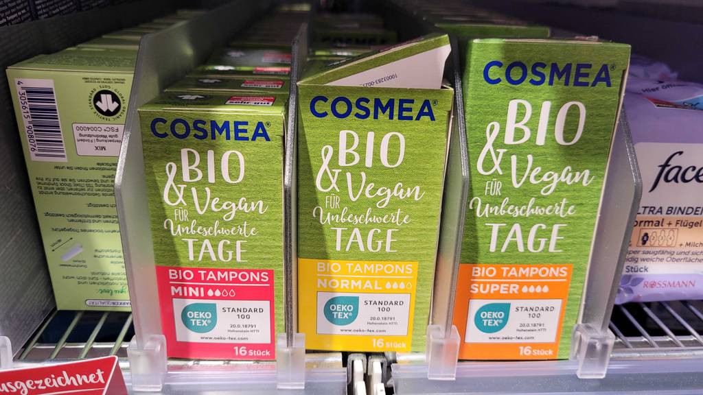 Mehrere Verpackungen mit Bio-Tampons im Test stehen auf einem Verkaufsregal nebeneinander.
