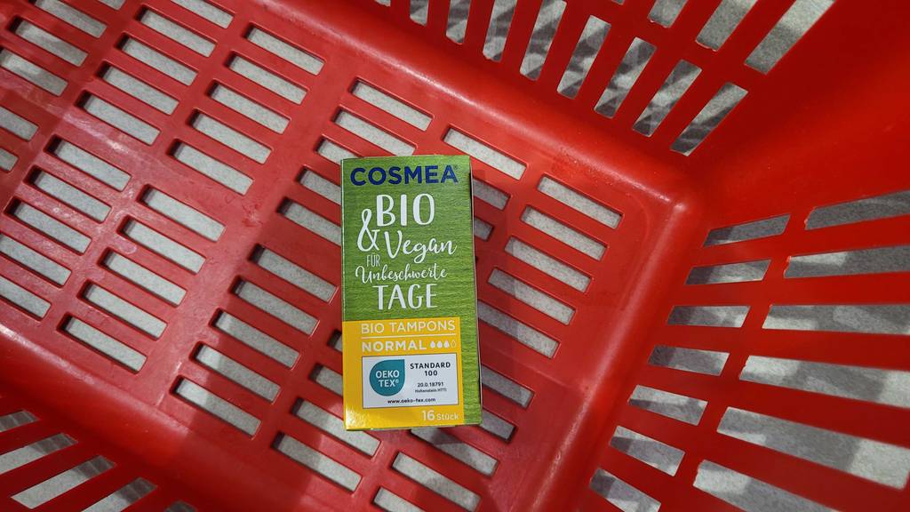 Bio-Tampon-Test: In einem roten Einkaufskorb liegt eine grüne Verpackung mit Bio-Tampons.