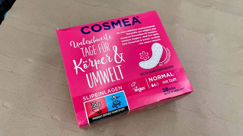 Cosmea-Slipeinlagen im Test in einer rosafarbenen 58-Stück-Verpackung liegen auf einem grauen Boden.