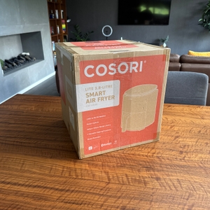 Der Karton der Cosori CAF-LI401S steht auf einem Tisch.