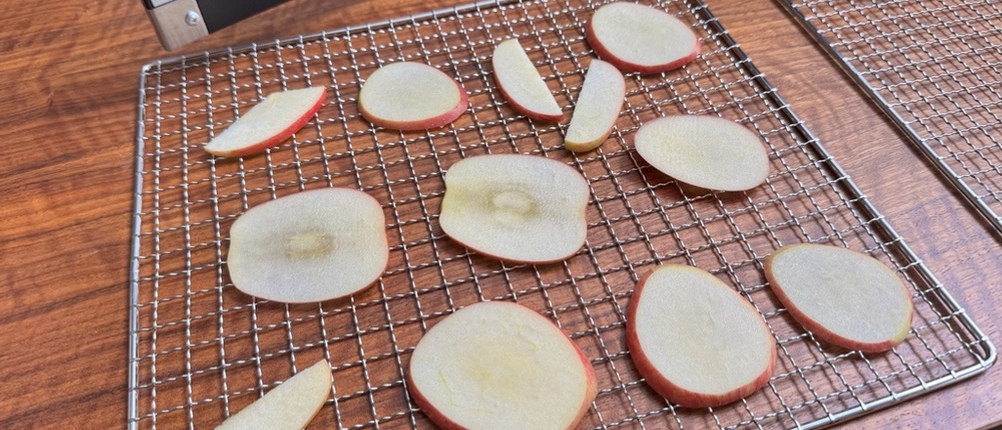 Auf einem Gitter des Cosori CP267-FD liegen vor dem Dörren Apfelscheiben