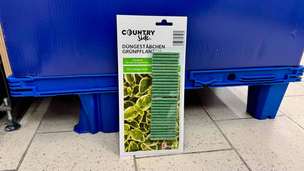 Eine Packung mit grünen getesteten Düngestäbchen steht vor einem blauen Hintergrund.