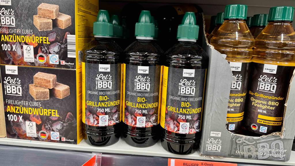 Grillanzünder flüssig im Test: Mehrere Flaschen stehen zwischen anderen Grillanzündern in einem Regal.