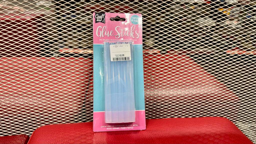 Heißklebesticks-Test: Eine Packung mit 10 Stück Klebesticks lehnt an einem Gitter.