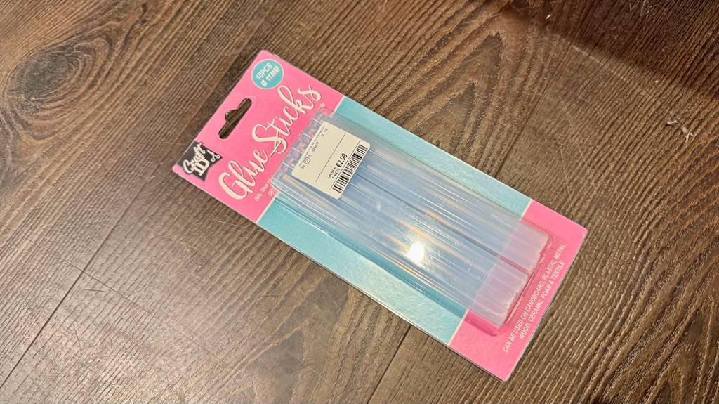 Heißklebesticks im Test: Eine Packung mit 10 Stück Klebesticks liegt auf einem Holzboden.