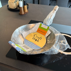 Der Craft wok 731W316 liegt in seiner Verpackung auf einer Kochplatte