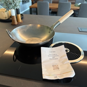 Der Craft wok 731W316 steht neben der Anleitung auf einer Kochplatte