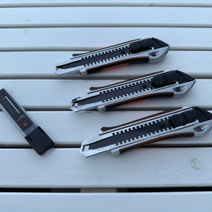 Drei Craftus CR-100 liegen neben Klingen auf einem Holztisch