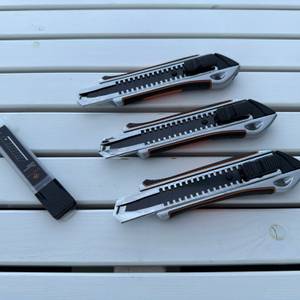 Drei Craftus CR-100 liegen neben Klingen auf einem Holztisch