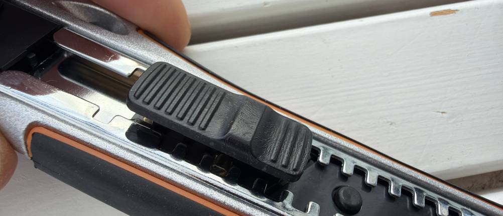 Das Plastik zum Verstellen der Klinge in Nahaufnahme