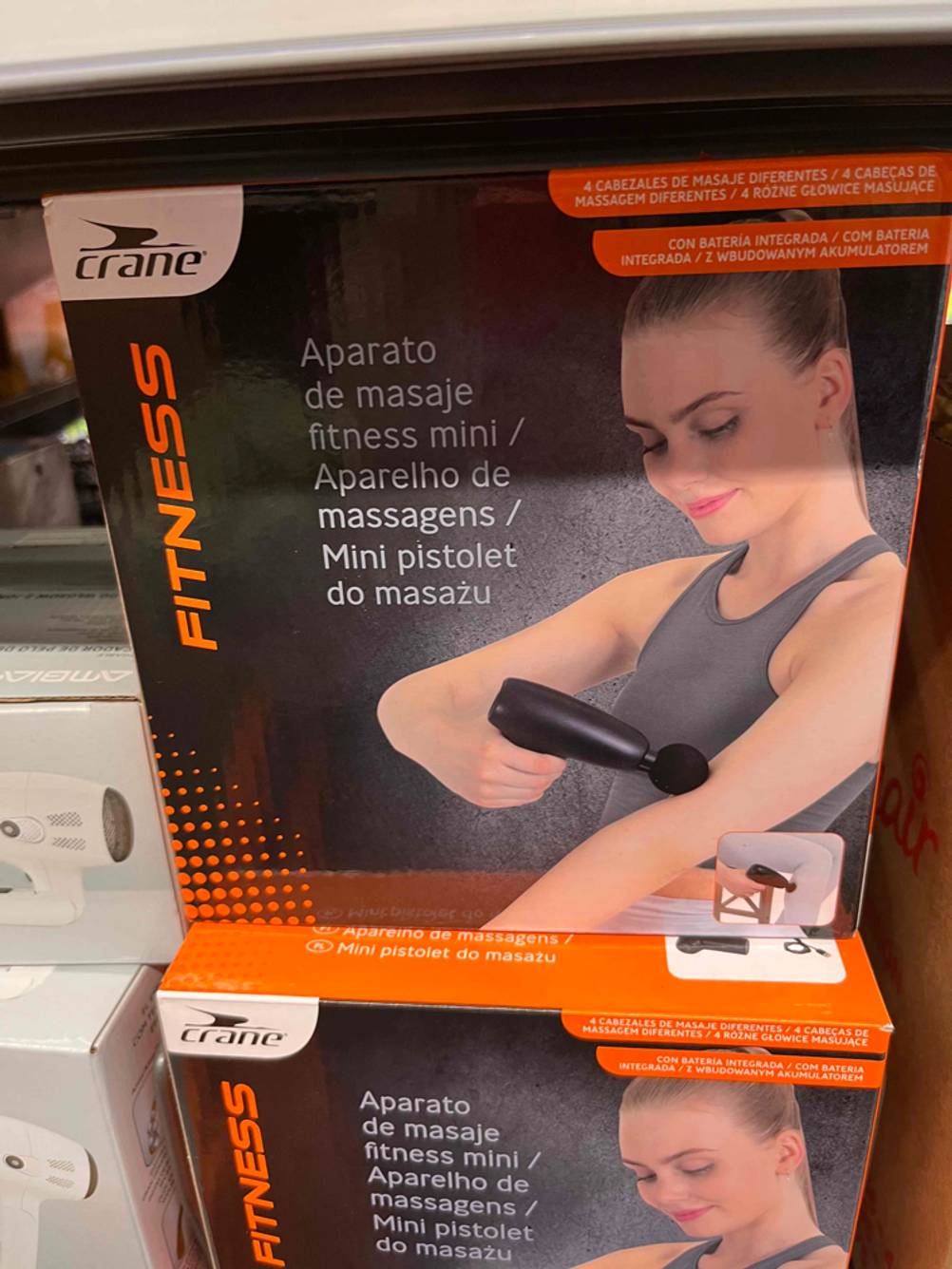 Eine getestete Massagepistole in Originalverpackung in einem Regal.