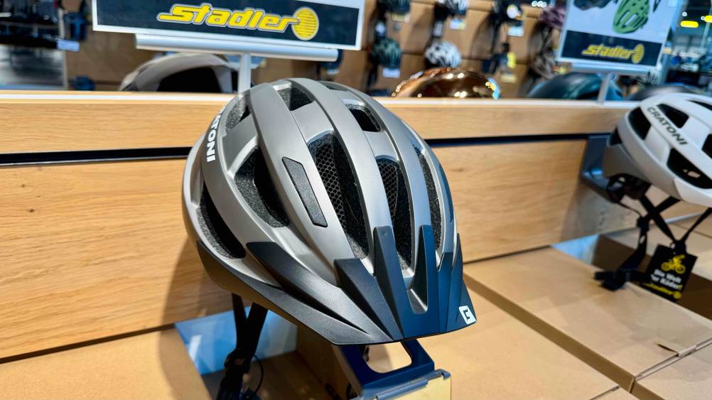 Der Cratoni-Fahrradhelm im Test von vorne in einem Ständer auf einem Verkaufsregal.