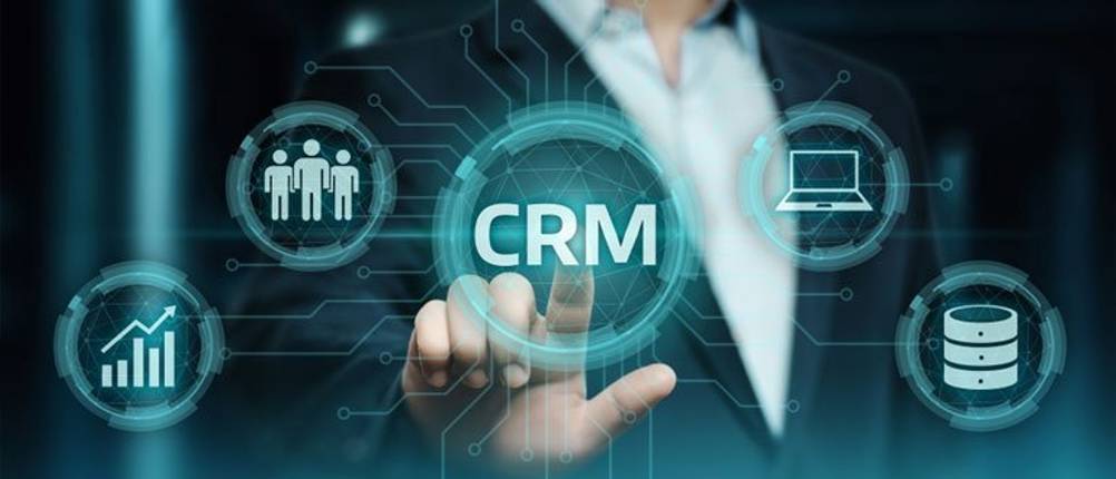 CRM-Software im Test: Eine futurische Grafik, bei der ein Hologramm mit dem Wort CRM von einem Menschen berührt wird.