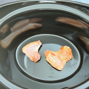 Zwei rohe Stücke Fleisch liegen im Behälter des Crock-Pot SCCPBPP605