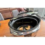 Eine Hand hebt den Deckel des Crock-Pot SCCPBPP605 nach dem Kochen ab