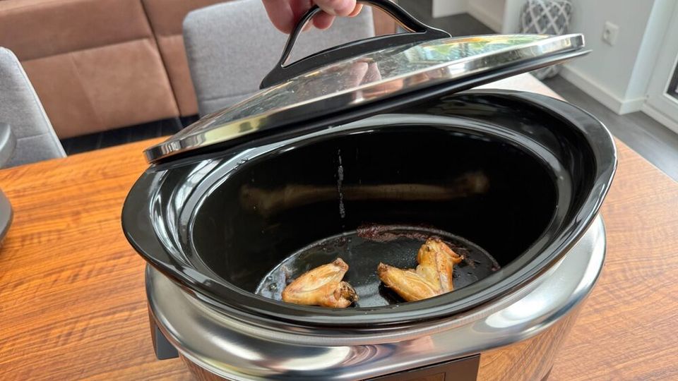 Eine Hand hebt den Deckel des Crock-Pot SCCPBPP605 nach dem Kochen ab