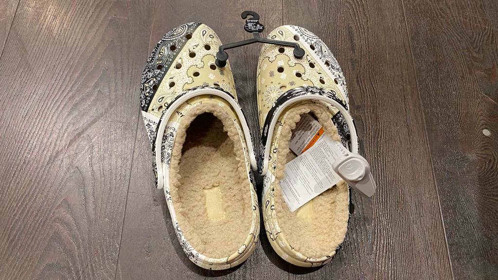 Ein Paar getestete Crocs von oben betrachtet stehen auf einem dunklen Boden.