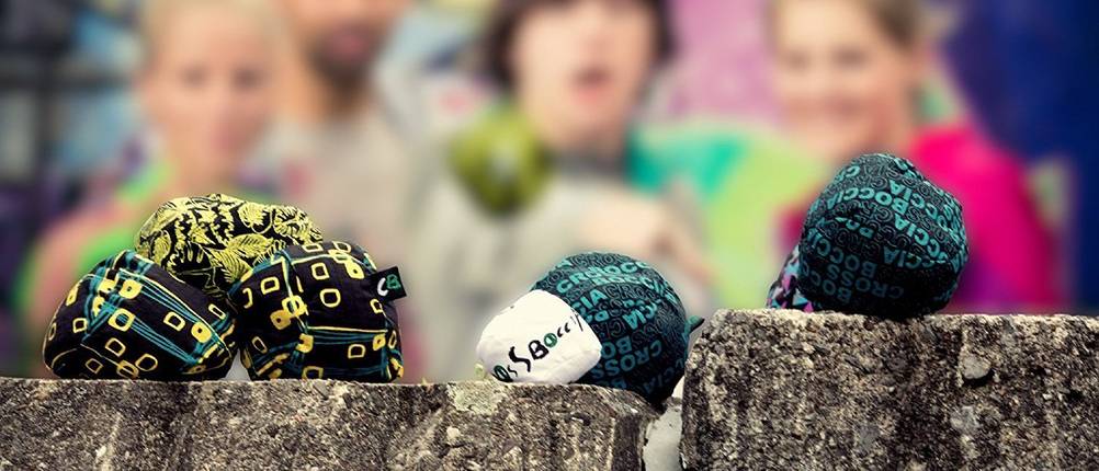 Crossboule-Test: 3 Personen spielen Crossboule. Die Bälle liegen auf Holzstämmen.