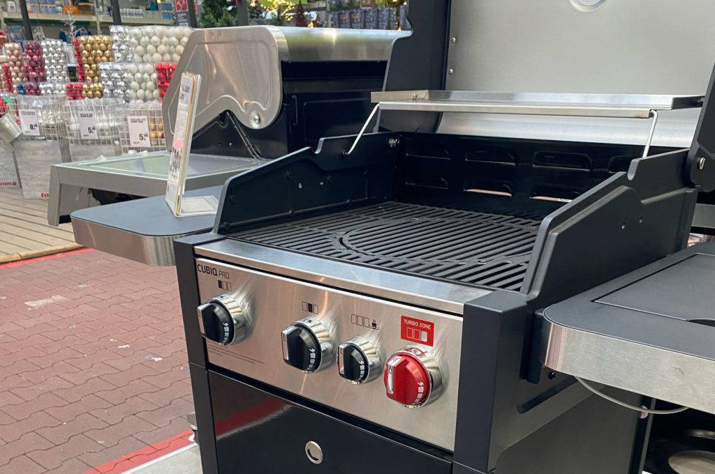 Gesamtansicht eines fahrbaren, getesteten Gasgrills mit Seitenbrenner von Cubiq in einem Verkaufsbereich.