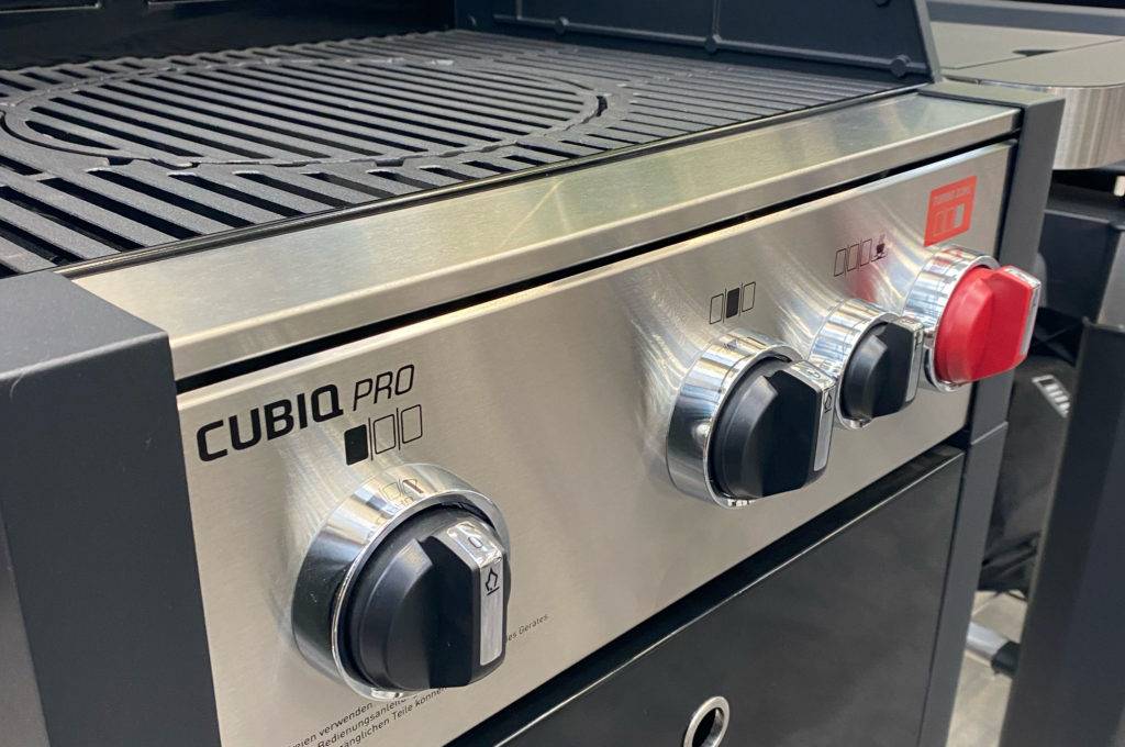 Gasgrill mit Seitenbrenner im Test: Nahaufnahme eines Modells der Marke Cubiq mit Fokus auf die Einstellungsknöpfe und den Grillrost.