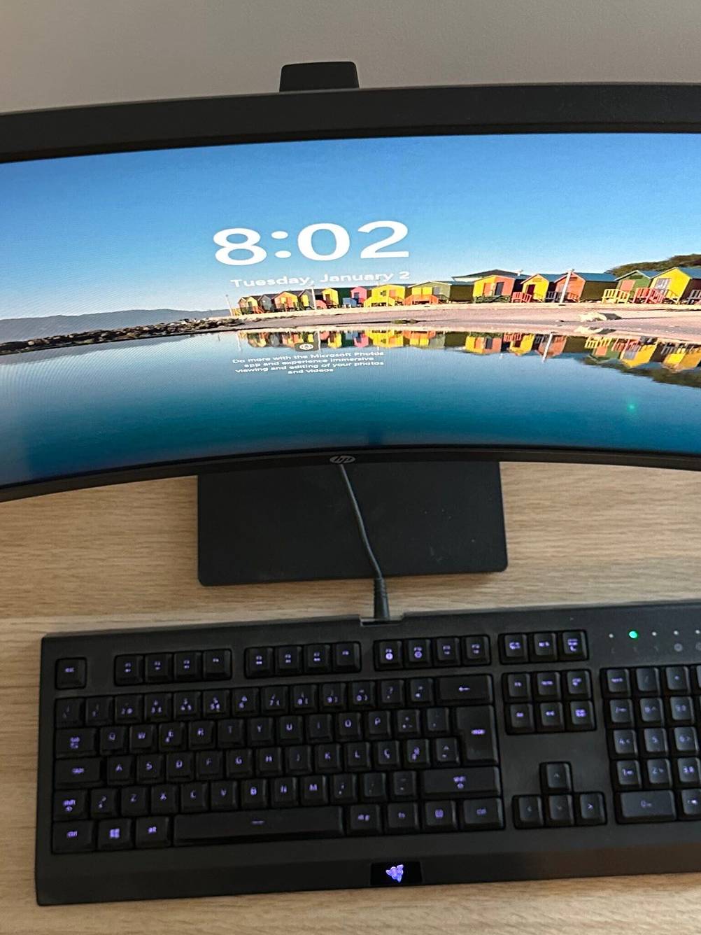 Ein getesteter Curved Monitor auf einem Schreibtisch von oben, davor eine Tastatur und eine Maus.