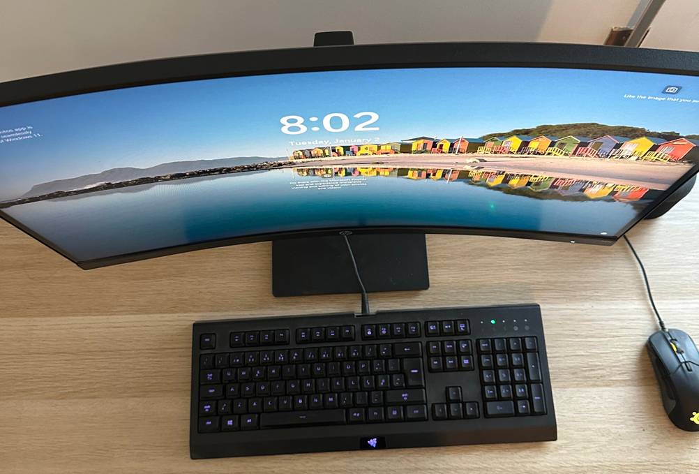 Ein getesteter ViewSonic Curved-Monitor auf einem Schreibtisch von oben, davor eine Tastatur und eine Maus.