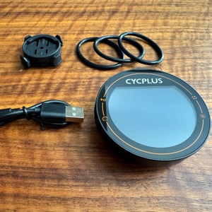 Der Lieferumfang des Cycplus-M2-Fahrradcomputer liegt auf einem Tisch