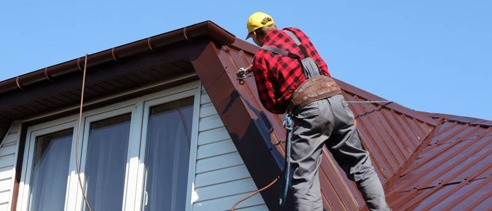 handwerker trägt neue dachfarbe auf