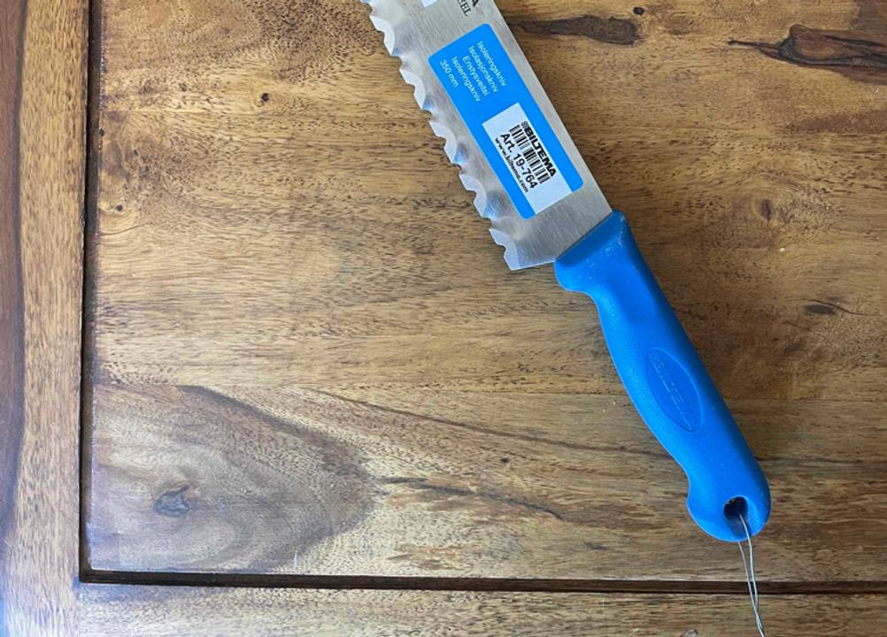 Nahaufnahme des Griffes eines getesteten Dämmstoffmesser auf einer Holzfläche.