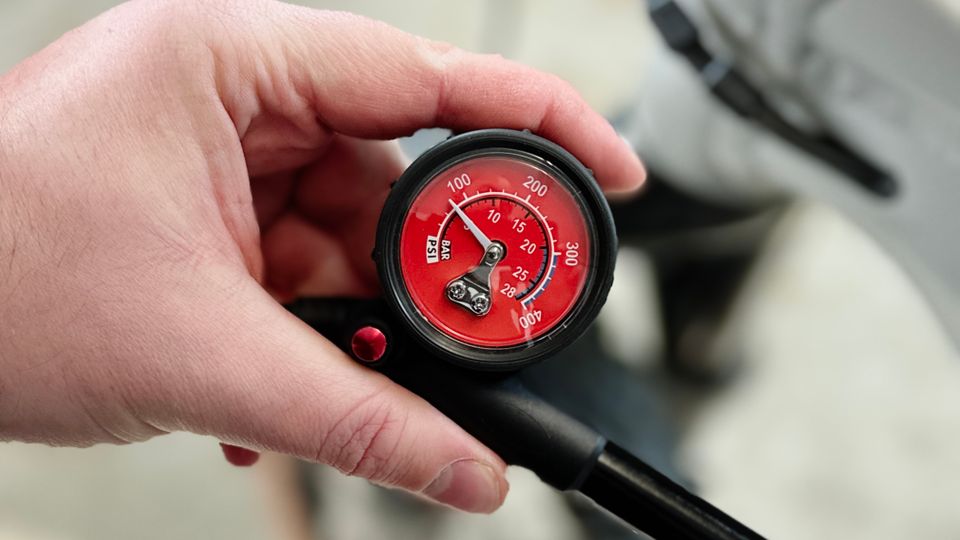 Die Pro Bike Tool BSP-01 wird mit beiden Händen gehalten. Der Pumpmechanismus ist vollständig ausgezogen.