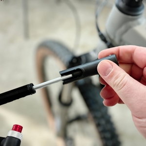 Eine Hand klappt den Griff der Pro Bike Tool BSP-01 aus. Der Mechanismus wird sichtbar entriegelt.