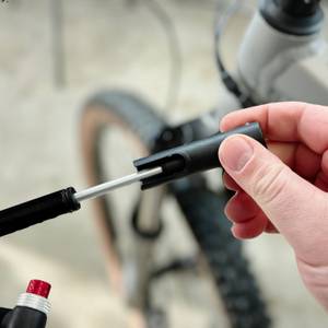 Eine Hand klappt den Griff der Pro Bike Tool BSP-01 aus. Der Mechanismus wird sichtbar entriegelt.