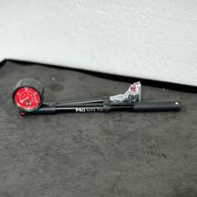 Die Pro Bike Tool BSP-01 liegt auf einer Werkbank. Manometer, Schlauch und Griff sind vollständig sichtbar.